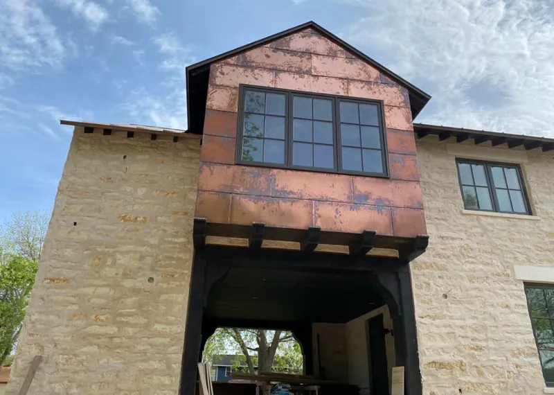 Copper metal panel facade on a stone building for Skylight Installation in Oelwein